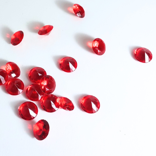 Red gemstones scattered on a white background