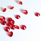 Red gemstones scattered on a white background